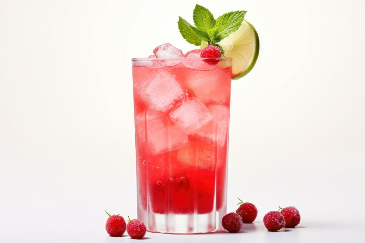 Glass filled with cranberry juice and ice with lime and greens for garnish